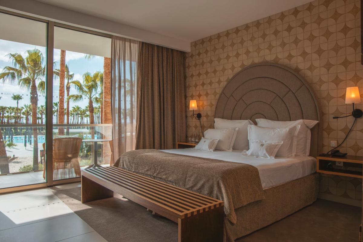 Um quarto com cama e vista para o oceano. em Wine & Books by the Sea, Algarve Resort em Albufeira Um quarto com cama e vista para o oceano. em Wine & Books by the Sea, Algarve Resort em Albufeira