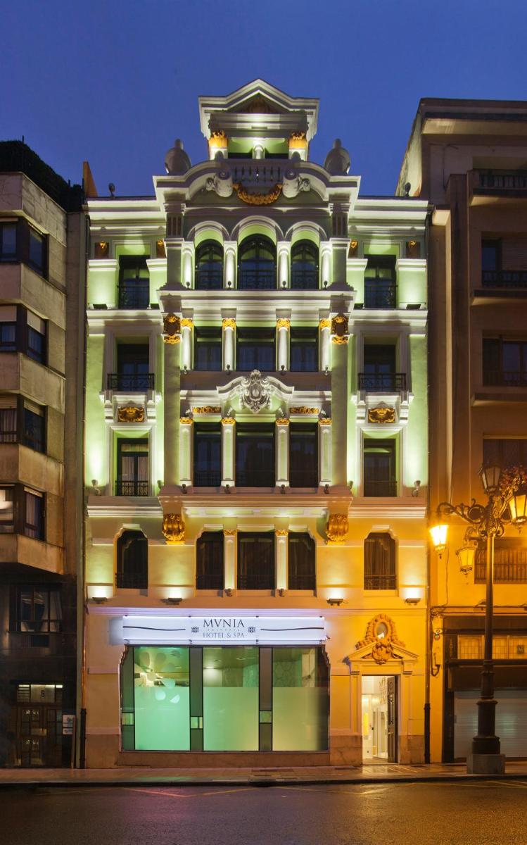 Un gran edificio con una tienda enfrente. en Hotel & Spa Princesa Munia, en Oviedo