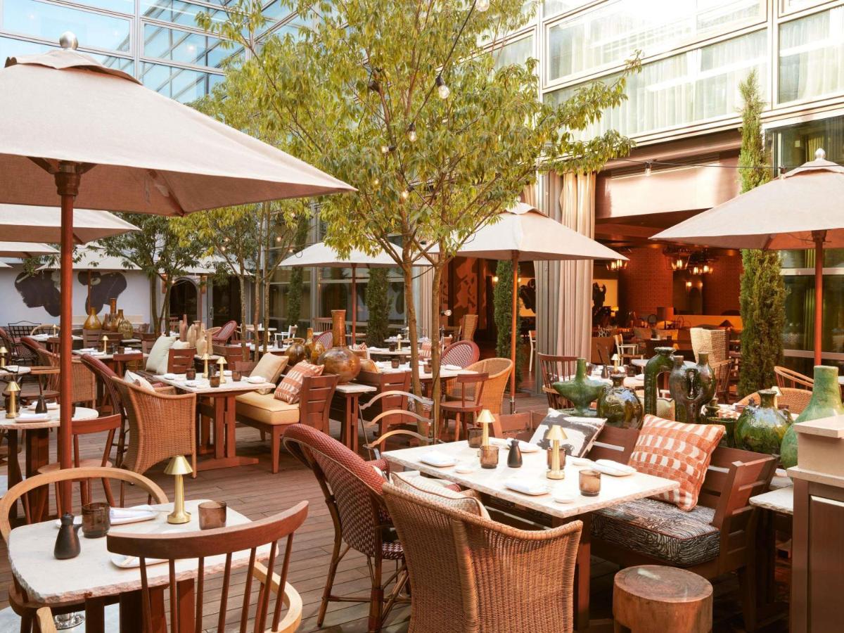 un restaurant en plein air avec tables, chaises et parasols dans l'établissement Mondrian Bordeaux Les Carmes, à Bordeaux
