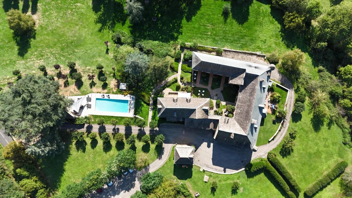 vue aérienne d'une maison avec piscine dans l'établissement Château de la Falque, The Originals Relais, à Saint-Geniez-dʼOlt