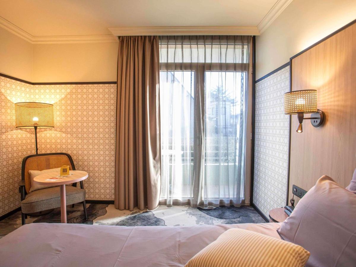 une chambre avec un lit, une table et une fenêtre dans l'établissement Mercure Granville Le Grand Large, à Granville 170 autres photos