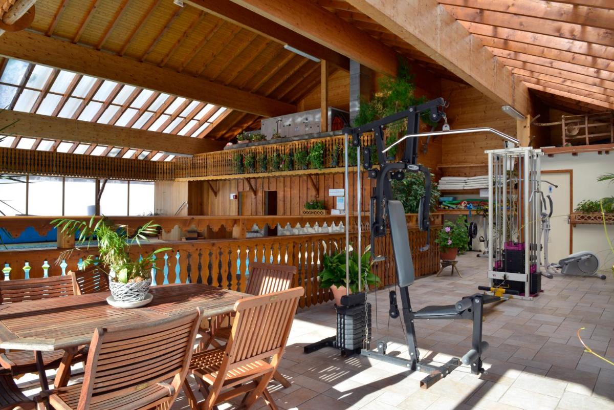 un patio avec une table, des chaises et des plantes dans l'établissement Hotel Le Ferraillon, à Abondance