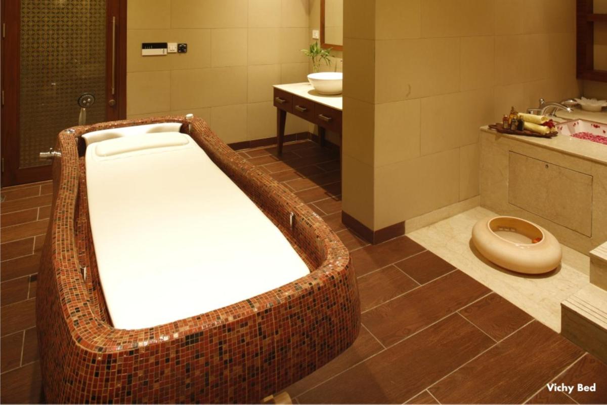 a bathroom with a bath tub and a toilet at Jaypee Palace Hotel in Agra