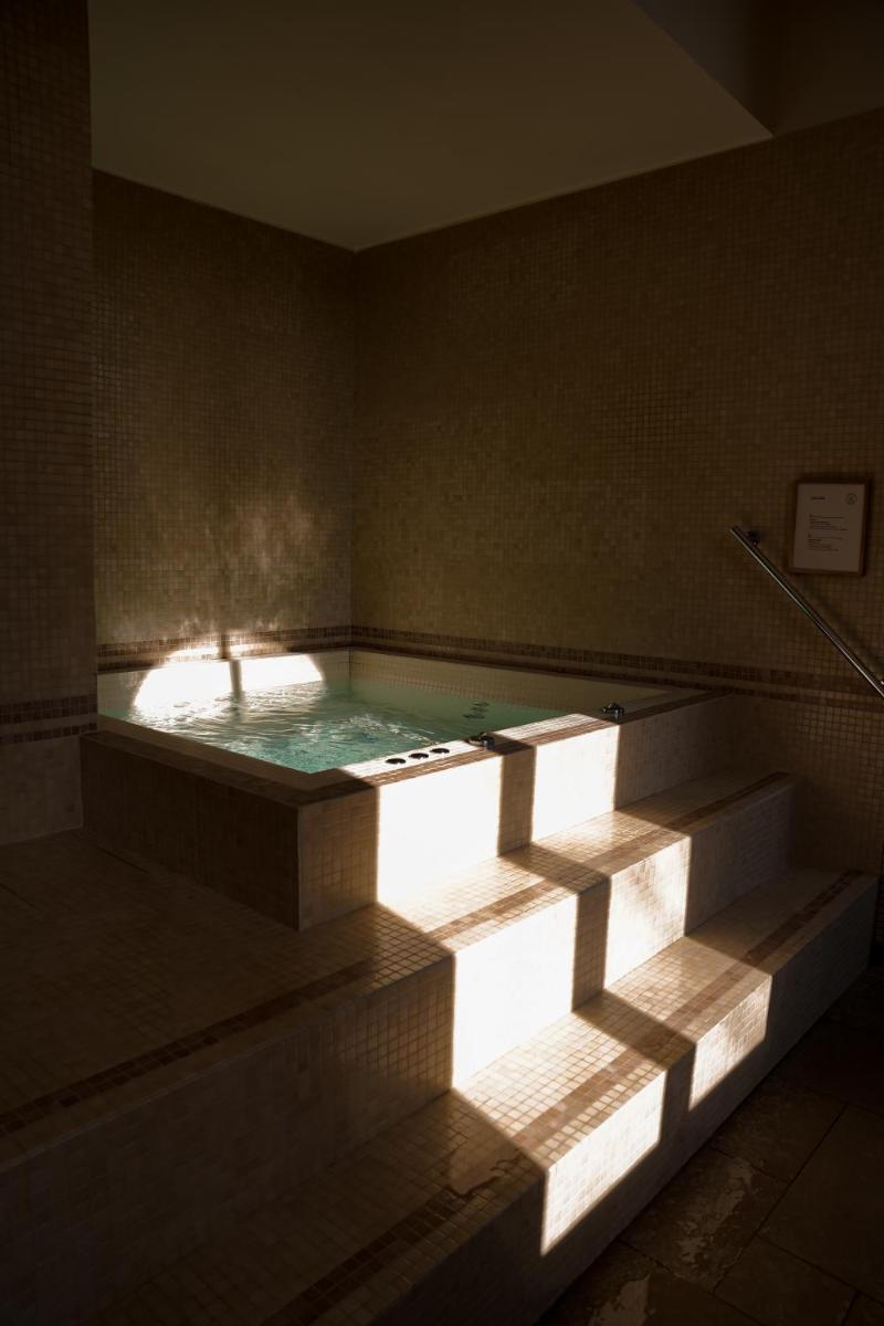 une piscine d'eau dans une pièce avec une baignoire dans l'établissement Fourvière Hôtel, à Lyon 68 autres photos