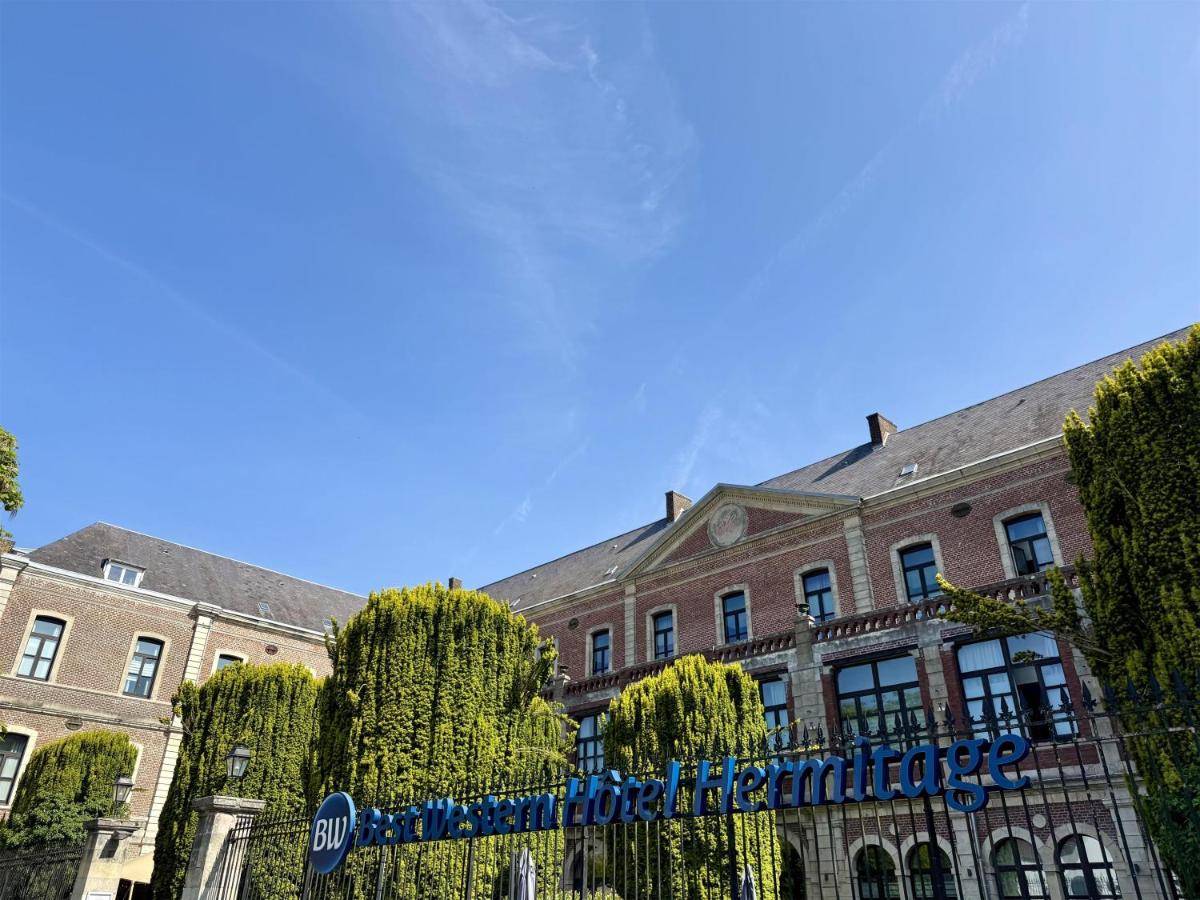 un grand bâtiment en briques avec une enseigne dessus dans l'établissement Best Western Hôtel Hermitage, à Montreuil-sur-Mer