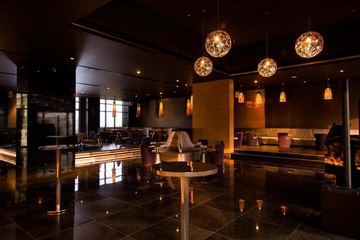 a restaurant with tables and chairs and lights at Feathers- A Radha Hotel, Chennai in Chennai