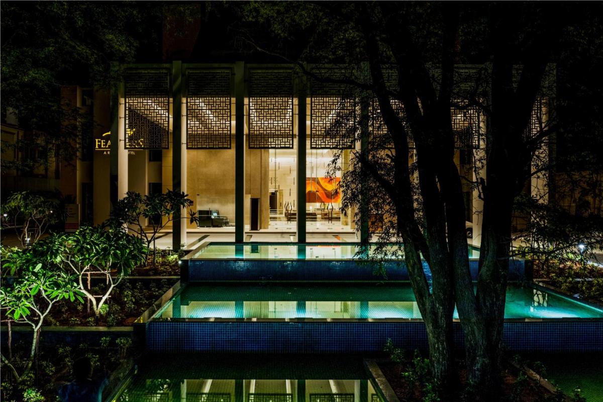a swimming pool in front of a building at night at Feathers- A Radha Hotel, Chennai in Chennai