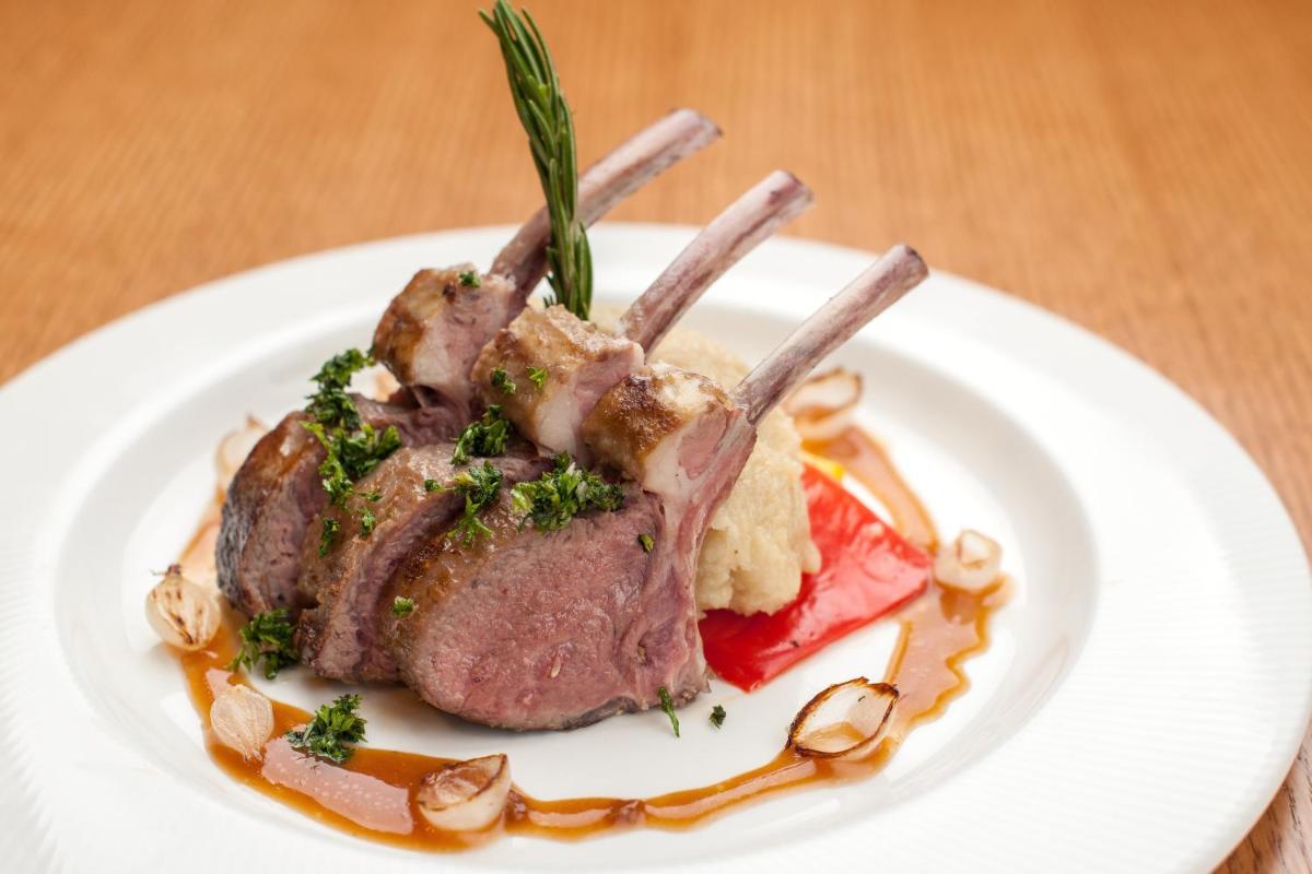 a piece of meat on a white plate with sauce at Feathers- A Radha Hotel, Chennai in Chennai