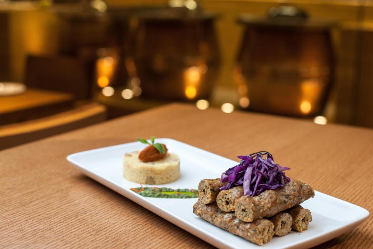 a white plate with some food on a table at Feathers- A Radha Hotel, Chennai in Chennai
