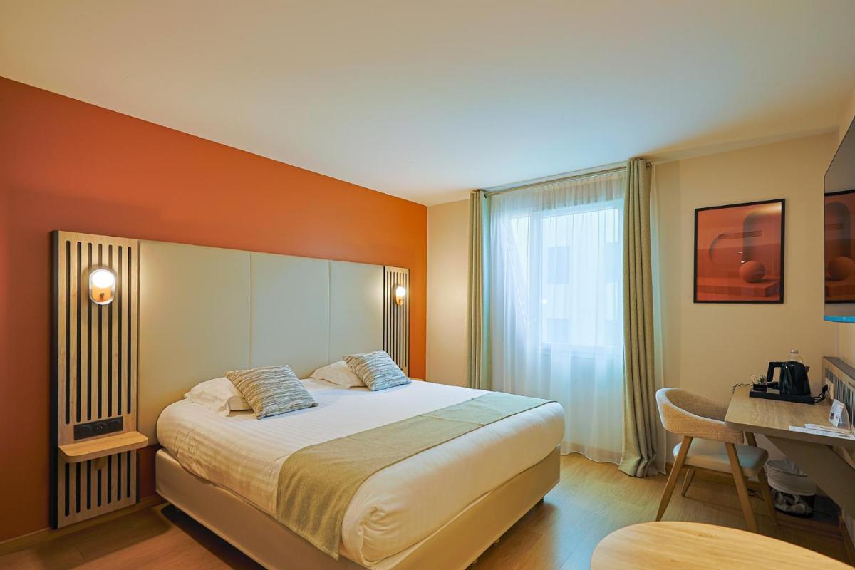 une chambre d'hôtel avec un lit et un bureau dans l'établissement Seven Urban Suites Nantes Centre, à Nantes