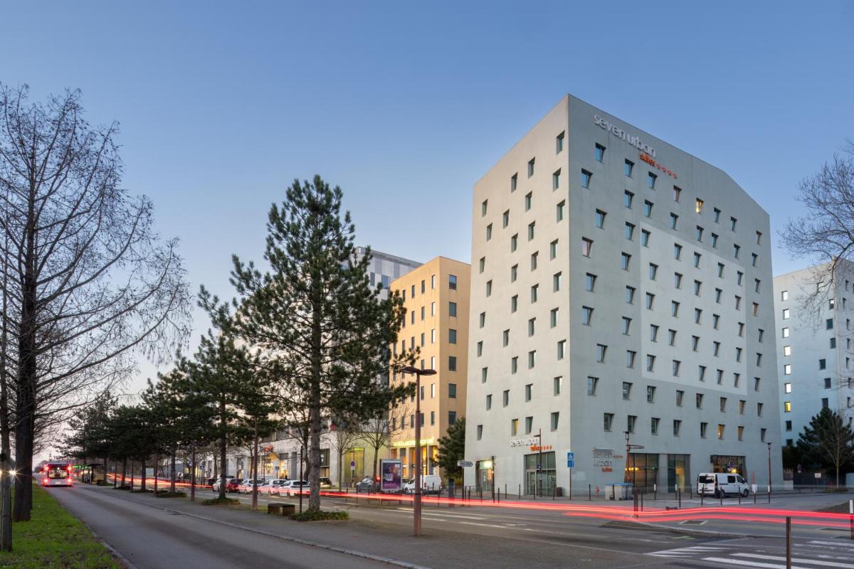 un grand bâtiment blanc dans une rue de la ville dans l'établissement Seven Urban Suites Nantes Centre, à Nantes
