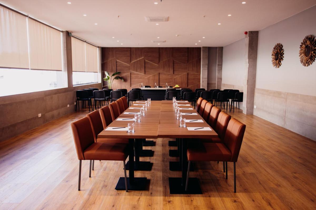 uma grande sala de jantar com uma mesa longa e cadeiras em The Prime Energize Hotel & SPA - Algarve em Monte Gordo mais 135 fotografias