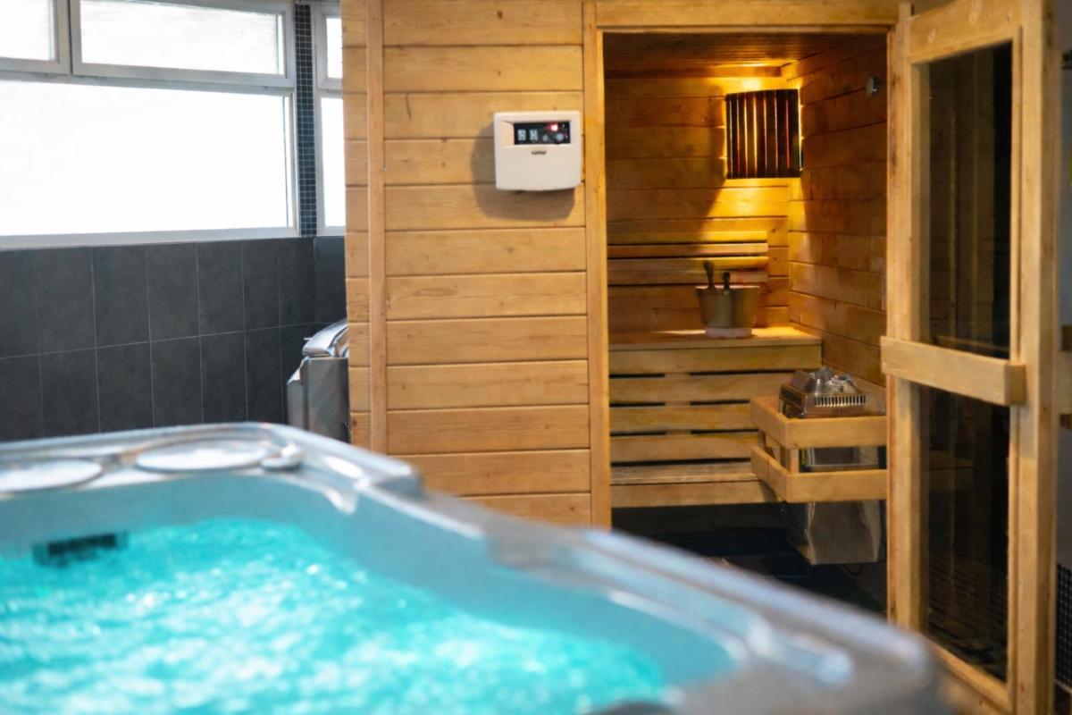une salle de bain avec baignoire dans une salle de bain en bois dans l'établissement Hotel Europa, à Quiberon