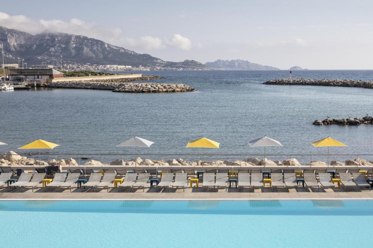 une piscine avec des chaises et un plan d'eau dans l'établissement nhow Marseille, à Marseille