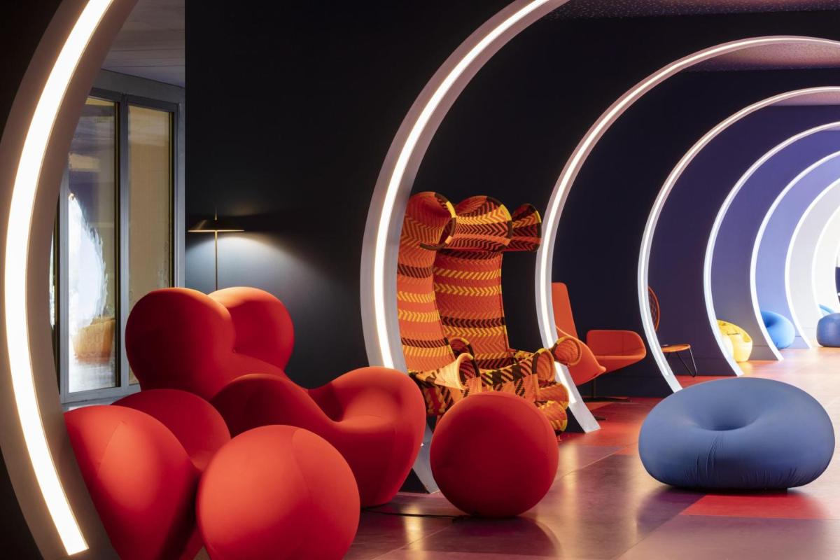 une pièce avec des chaises rouges et un miroir dans l'établissement nhow Marseille, à Marseille
