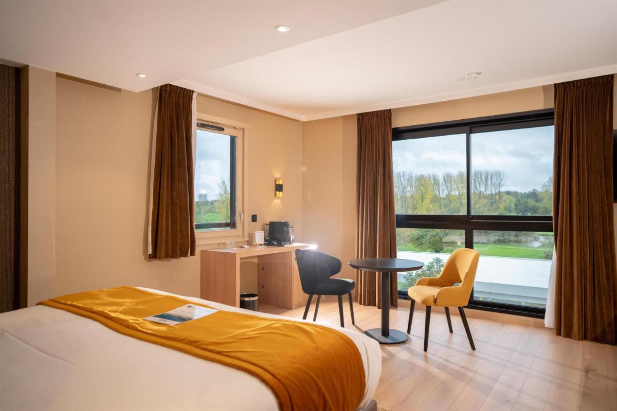 une chambre d'hôtel avec un lit, une table et des chaises dans l'établissement Best Western Plus Le Fairway Hotel & Spa Golf d'Arras, à Anzin-Saint-Aubin
