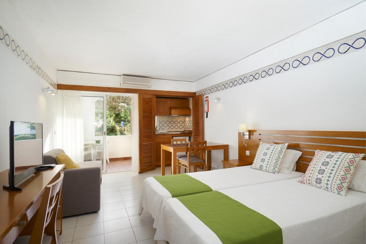 um quarto com uma cama e uma sala de estar em Golden Club Cabanas em Cabanas de Tavira