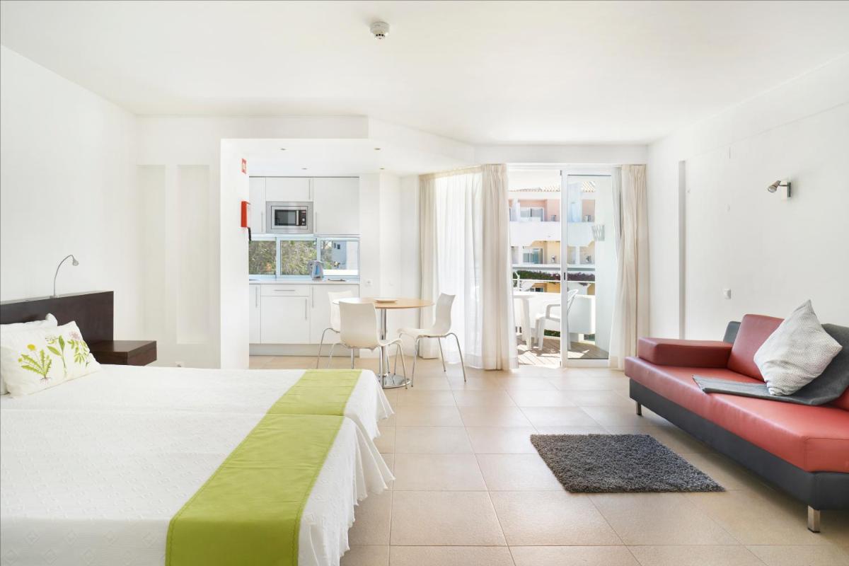 um quarto com uma cama, um sofá e uma mesa em Golden Club Cabanas em Cabanas de Tavira