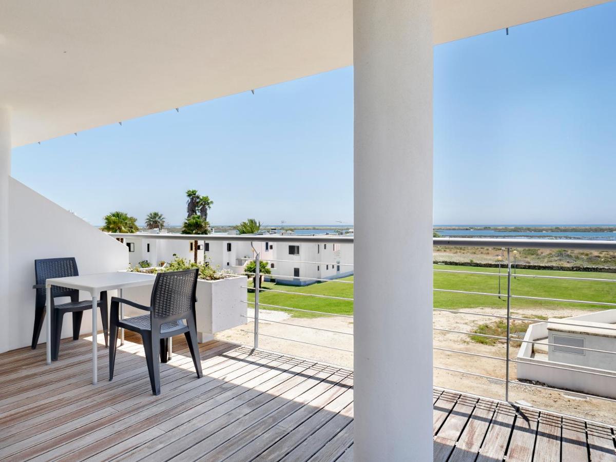 uma vista a partir da varanda de uma casa com uma mesa e cadeiras em Golden Club Cabanas em Cabanas de Tavira