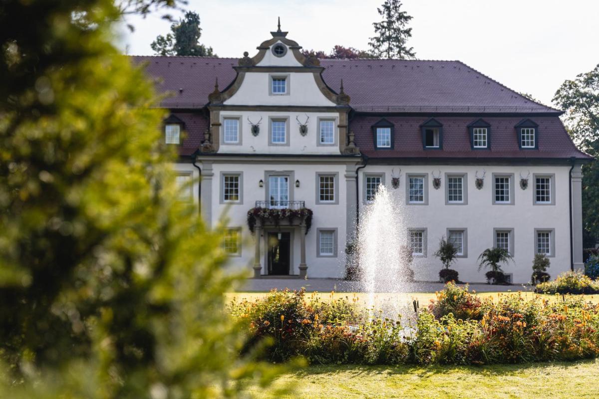 ein großes weißes Gebäude mit einem Brunnen davor in der Unterkunft Wald & Schlosshotel Friedrichsruhe in Friedrichsruhe