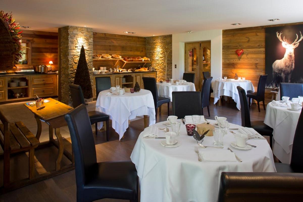 une salle à manger avec des tables, des chaises et un tissu de table blanc dans l'établissement Chalet-Hôtel Hermitage, à Chamonix-Mont-Blanc