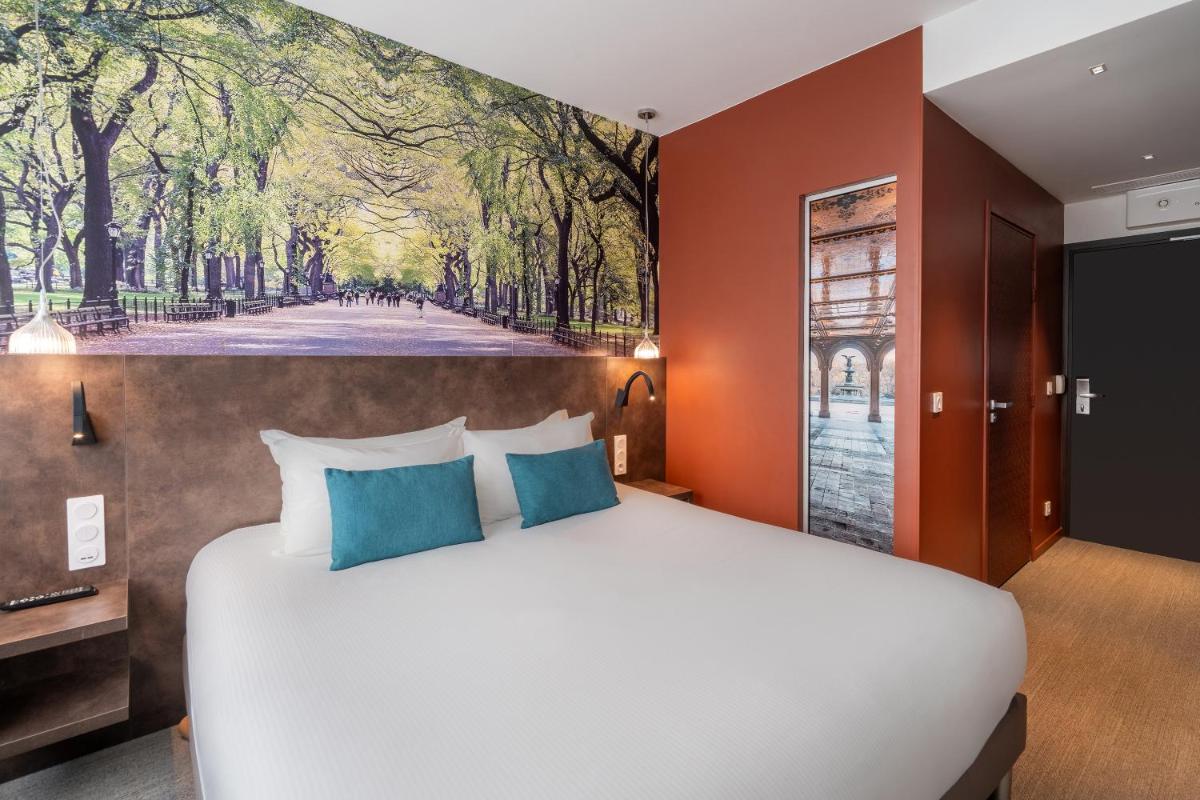 une chambre avec un lit et un tableau au mur dans l'établissement BW Plus Central Park Hotel & Spa, à La Rochelle