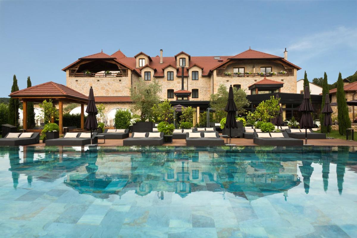 une grande piscine devant un bâtiment dans l'établissement Domaine de la Klauss & Spa, Restaurant Gastronomique Le K, à Montenach