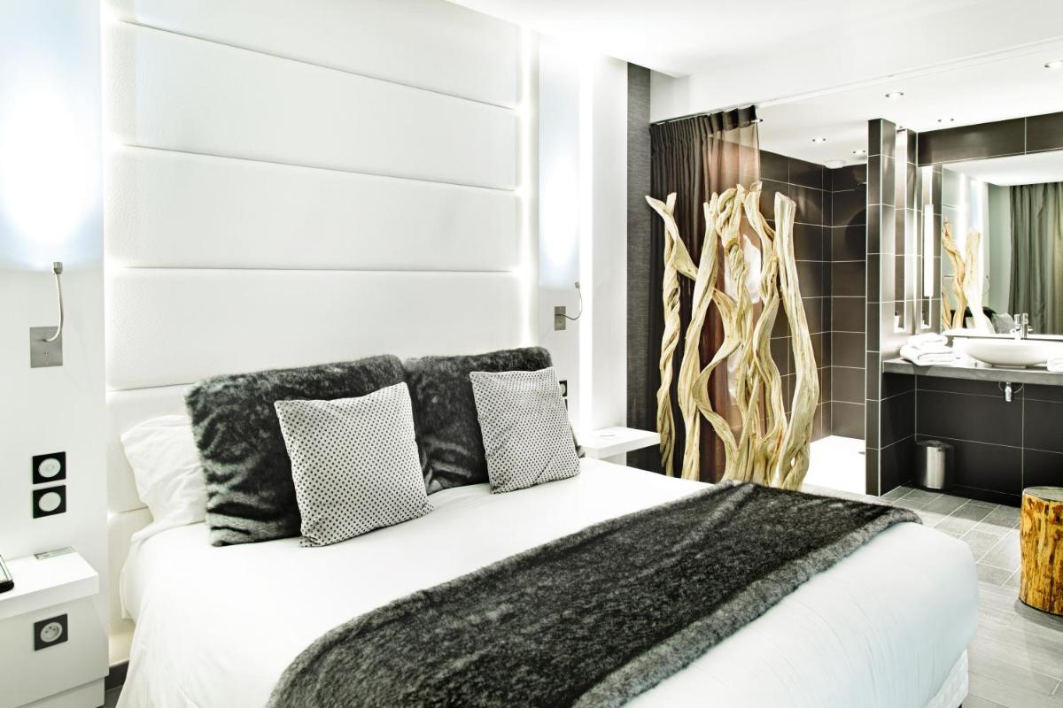 une chambre avec un lit blanc et une salle de bain dans l'établissement Hôtel Le Parc - La Table de Franck Putelat, à Carcassonne
