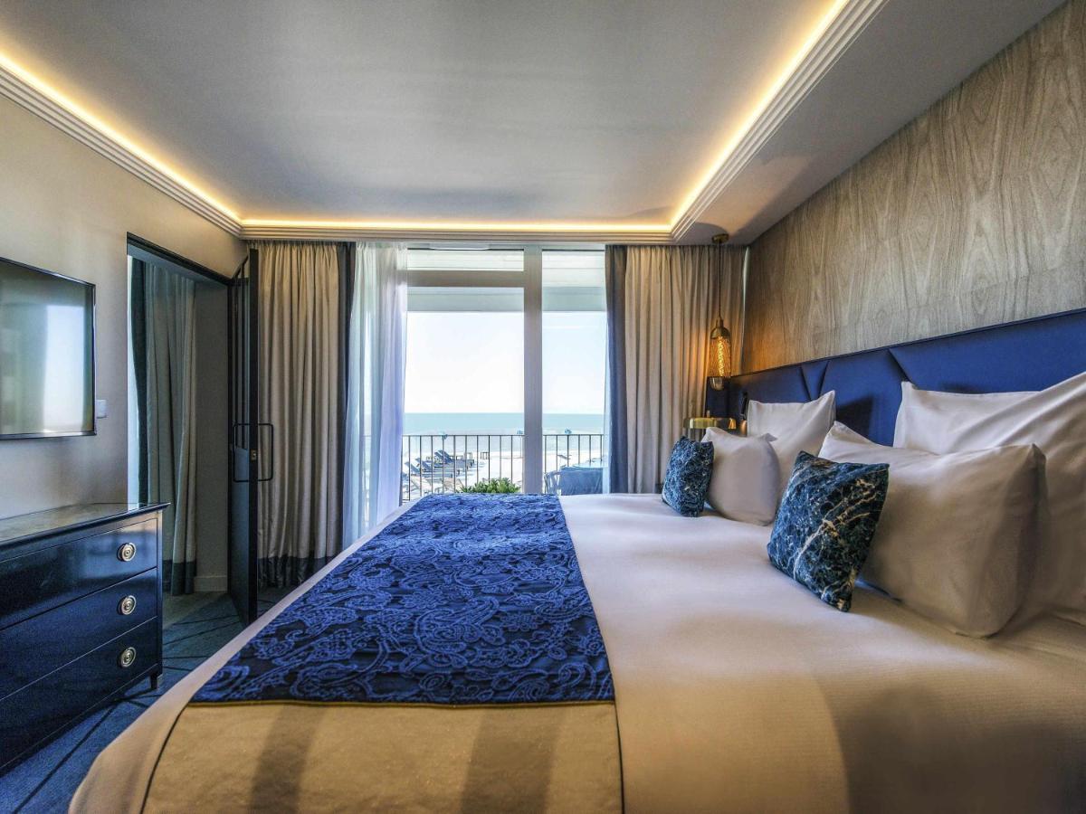 une chambre avec un grand lit et une grande fenêtre dans l'établissement La Grande Terrasse Hotel & Spa La Rochelle - MGallery Collection, à Châtelaillon-Plage