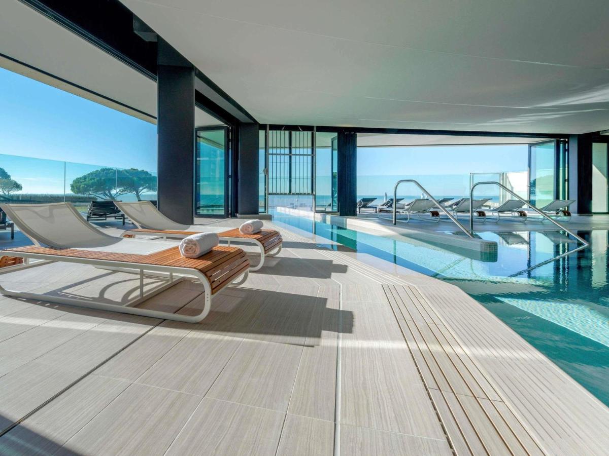 une chambre avec trois lits et une piscine dans l'établissement La Grande Terrasse Hotel & Spa La Rochelle - MGallery Collection, à Châtelaillon-Plage