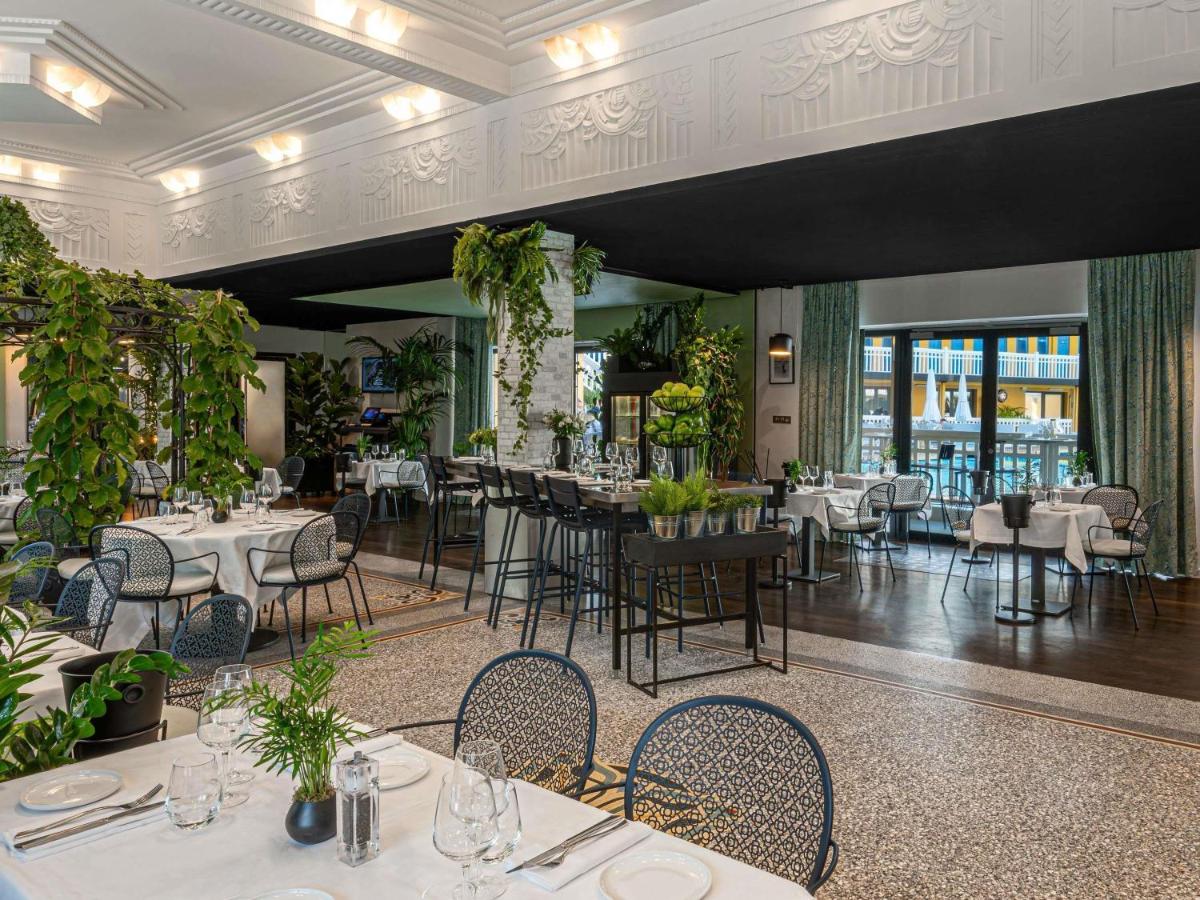 un restaurant avec des tables, des chaises et des plantes dans l'établissement Molitor Hotel & Spa Paris - MGallery Collection, à Paris