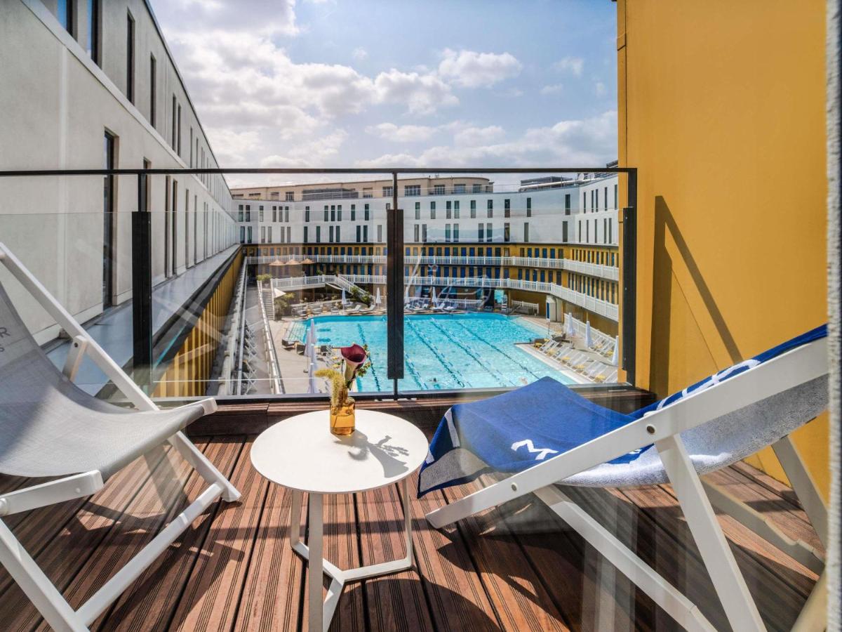 un balcon avec deux chaises et une piscine dans l'établissement Molitor Hotel & Spa Paris - MGallery Collection, à Paris