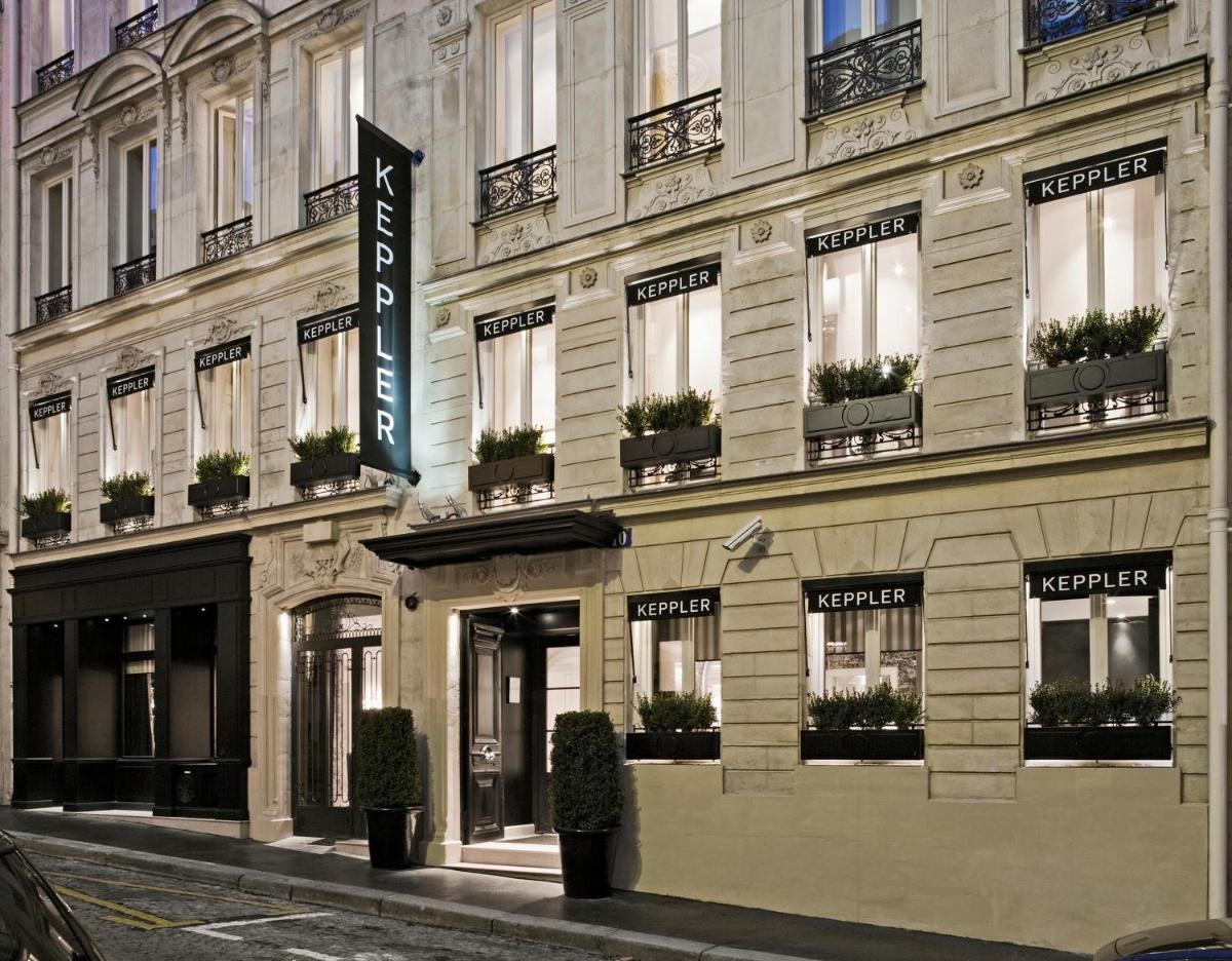 un bâtiment avec une enseigne sur le côté dans l'établissement Hôtel Keppler, à Paris