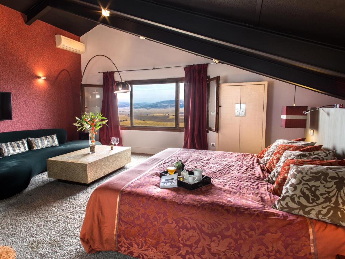Un dormitorio con una cama grande y un sofá. en Hotel Cardamomo Sigüenza, en Carabias