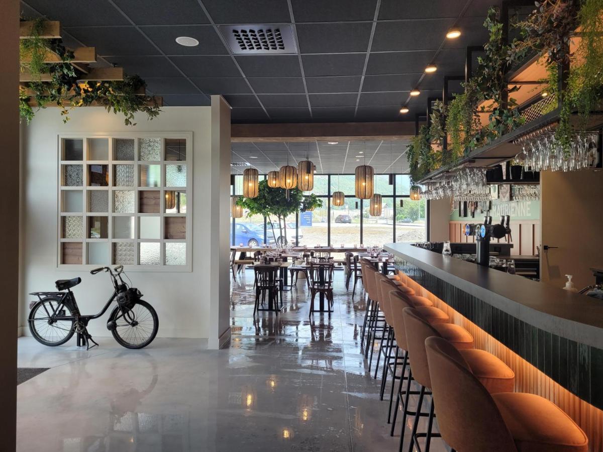 un restaurant avec un vélo garé à côté d'un bar dans l'établissement Best Western Coeur de Maurienne Hotel Restaurant & Spa, à Saint-Jean-de-Maurienne