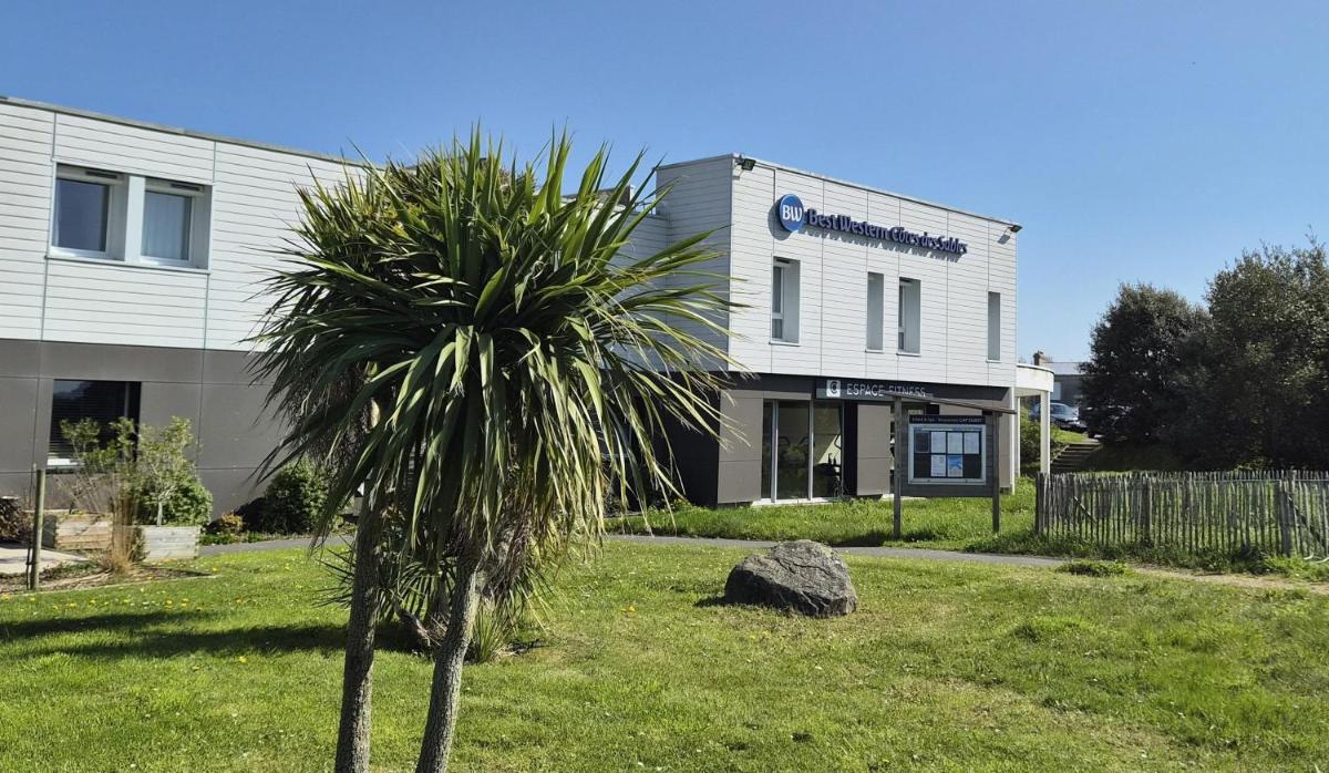 un palmier devant un bâtiment dans l'établissement Best Western Côte des Sables Plouescat, à Plouescat