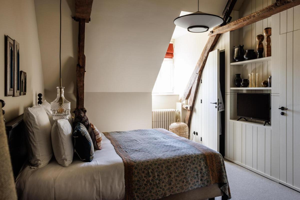 une chambre avec un lit et une télévision dans une pièce dans l'établissement Domaine de Locguénolé & Spa - Relais & Chateaux, à Kervignac