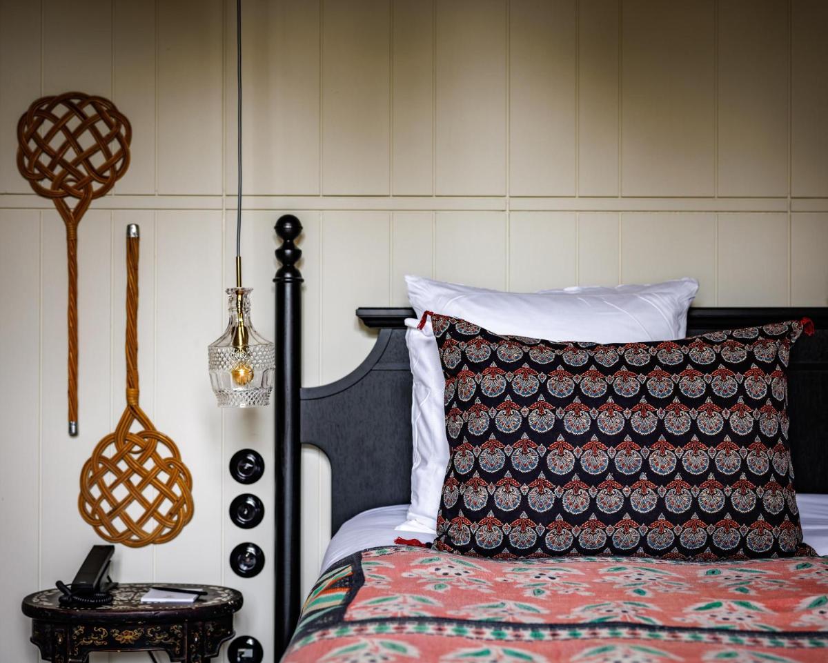 une chambre avec un lit et une table avec une lampe dans l'établissement Domaine de Locguénolé & Spa - Relais & Chateaux, à Kervignac