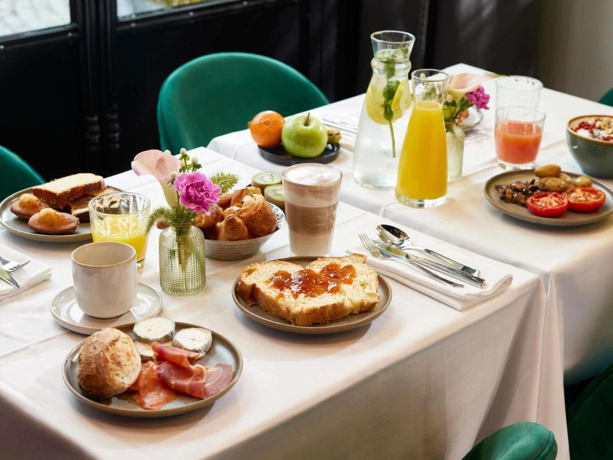 une table avec des aliments et des boissons pour le petit-déjeuner dessus dans l'établissement Molitor Hotel & Spa Paris - MGallery Collection, à Paris