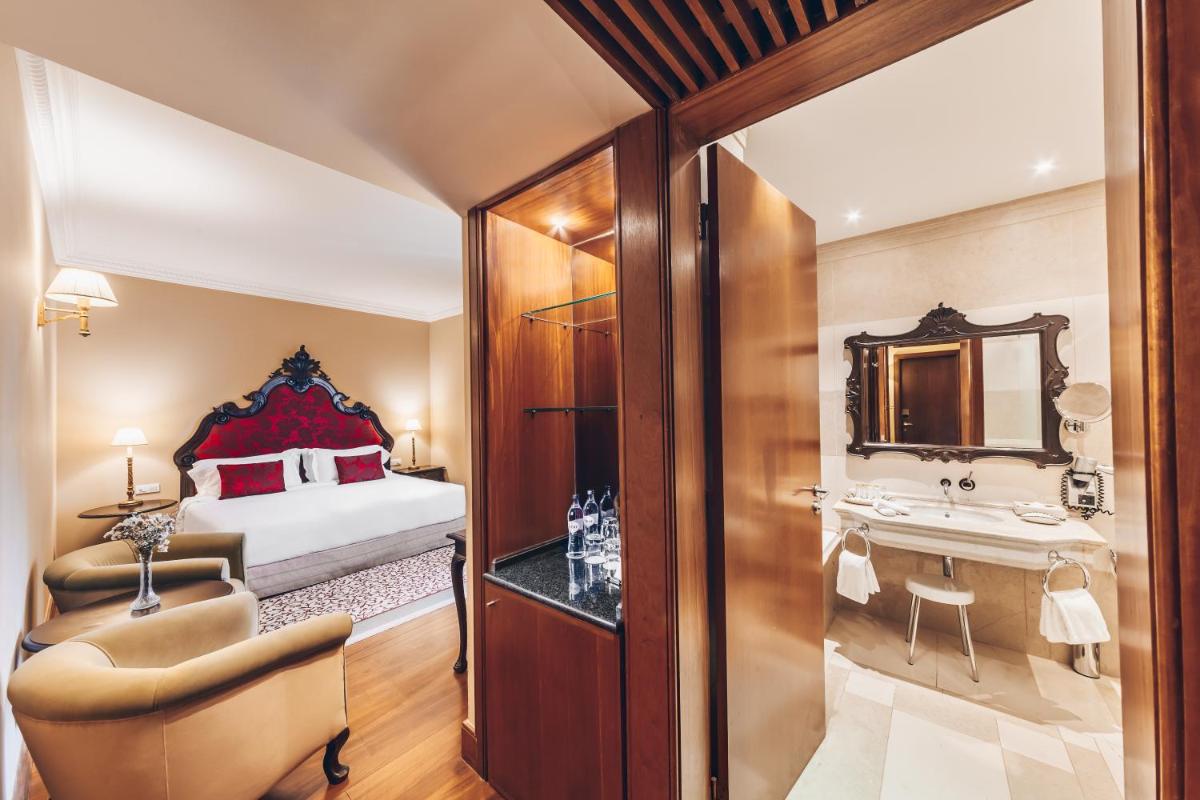 um quarto com uma cama e um banheiro com uma pia em Convento do Espinheiro, Historic Hotel & Spa em Évora