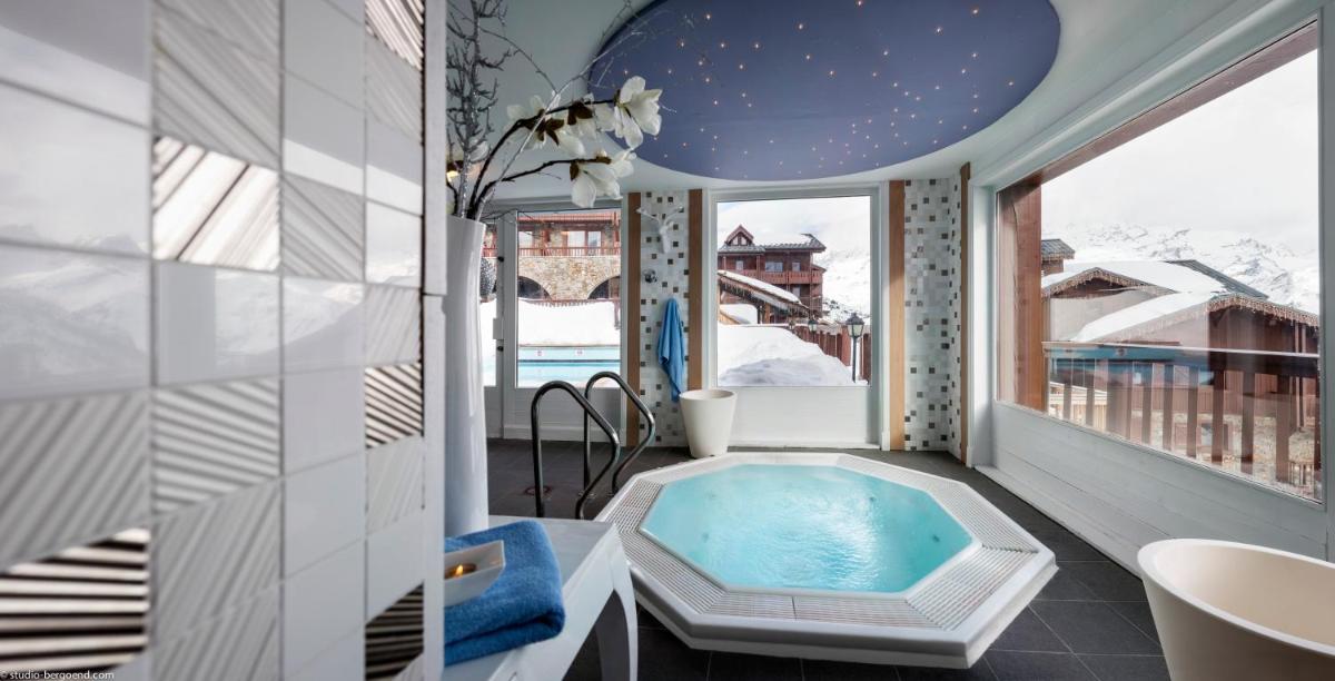 une salle de bains avec baignoire balnéo sur un balcon dans l'établissement Hôtel Village Montana by Les Etincelles, à Tignes
