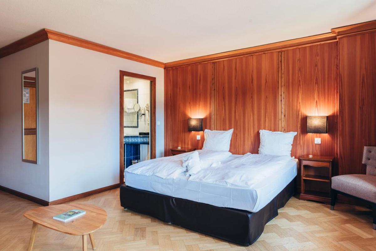Un ou plusieurs lits dans un hébergement de l'établissement Hotel Spa et Restaurant Au Chasseur