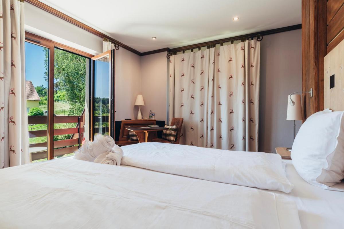 Un ou plusieurs lits dans un hébergement de l'établissement Hotel Spa et Restaurant Au Chasseur