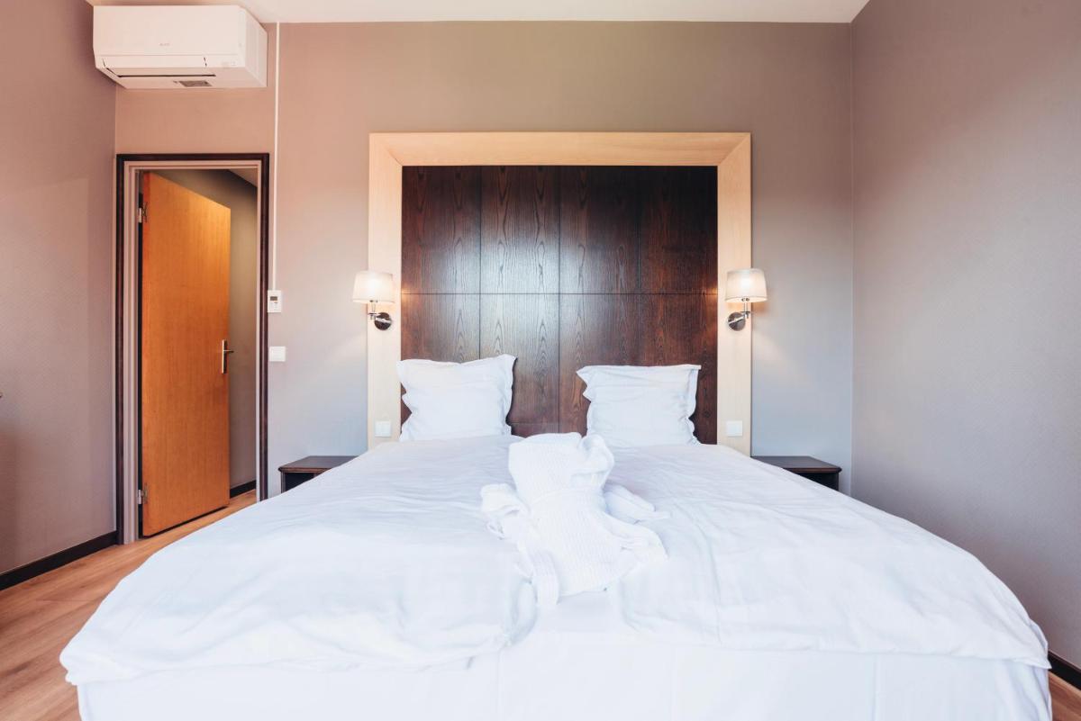 Un ou plusieurs lits dans un hébergement de l'établissement Hotel Spa et Restaurant Au Chasseur