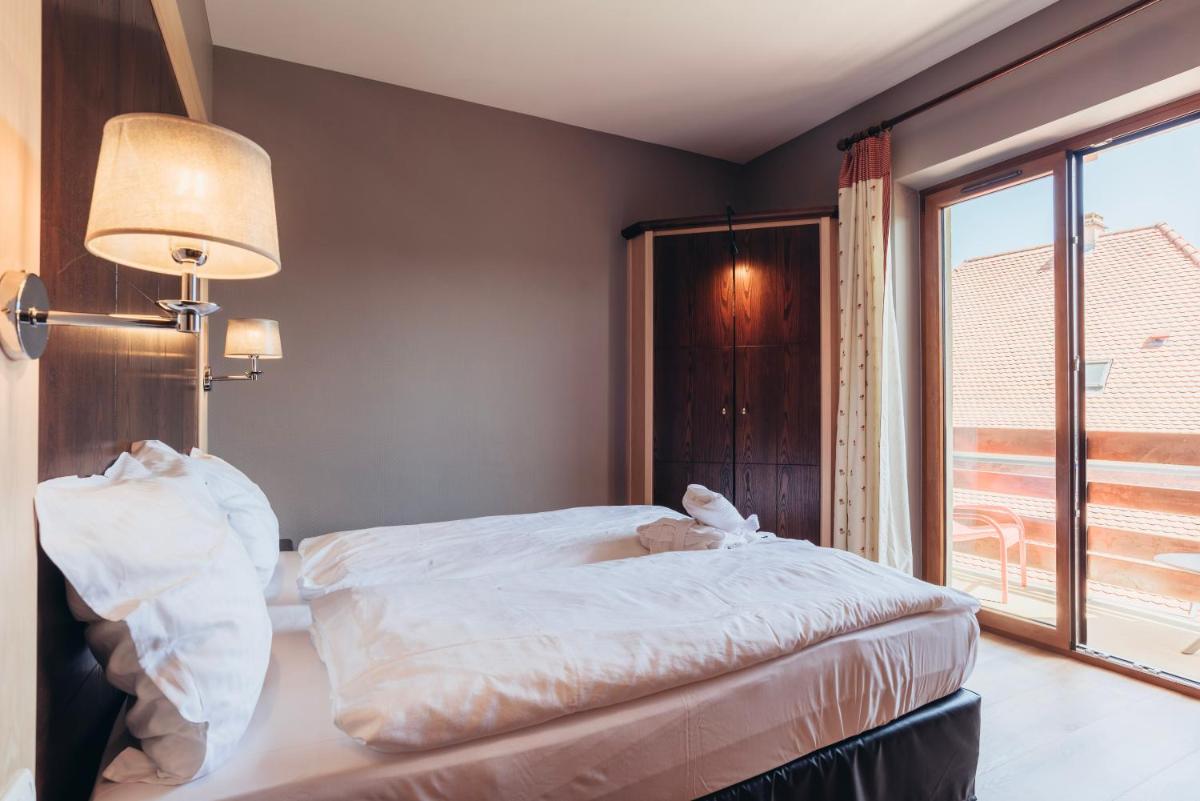Un ou plusieurs lits dans un hébergement de l'établissement Hotel Spa et Restaurant Au Chasseur