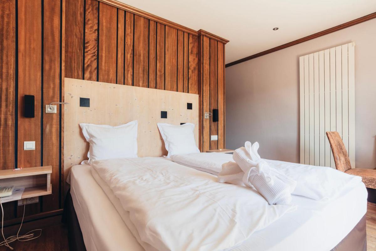 Un ou plusieurs lits dans un hébergement de l'établissement Hotel Spa et Restaurant Au Chasseur