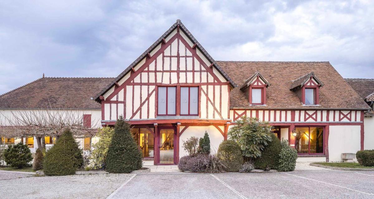 une grande maison avec un toit à deux versants. dans l'établissement Auberge du Lac, Sure Hotel Collection by Best Western, à Mesnil-Saint-Père