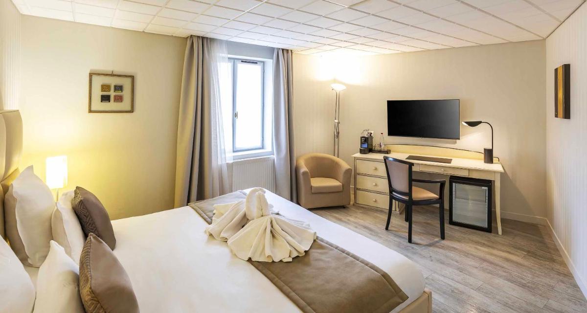 une chambre d'hôtel avec un lit et un bureau avec une télévision dans l'établissement Auberge du Lac, Sure Hotel Collection by Best Western, à Mesnil-Saint-Père