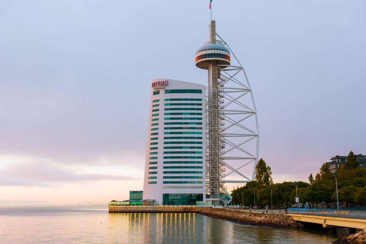 um prédio alto ao lado de um corpo d'água em MYRIAD by SANA Hotels em Lisboa