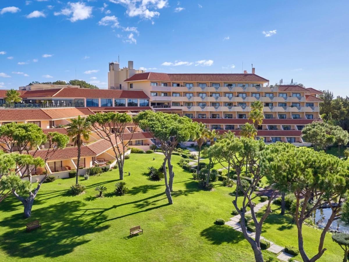 um resort com relvado e árvores em frente a um edifício em Hotel Quinta do Lago na Quinta do Lago